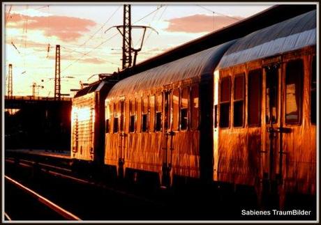 Sonnenuntergang am Bahnhof, das Licht lässt die Zugwaggons glühen