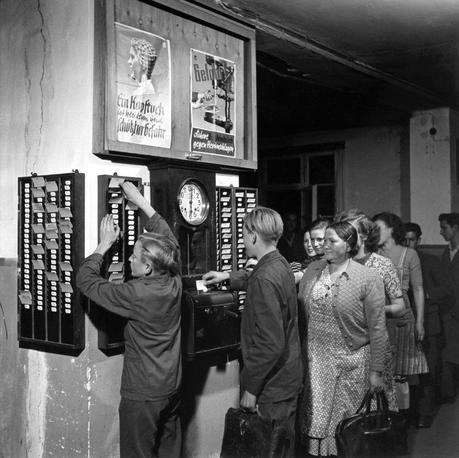 Präsenzkultur und Mütter: Wir brauchen eine Abwesenheitskultur, Foto: Arbeiter an der Stechuhr, um 1950, Kienzle Taxameter, Villingen (Uhrenindustriemuseum Villingen-Schwenningen)
