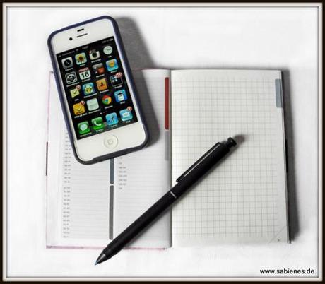 Notizbuch mit Kuli und Smartphone