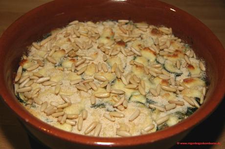 Fertig gebackener Zucchini-Couscous-Auflauf mit Pinienkernen