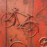 Fahrrad in rot an einer Wand befestigt twicepix