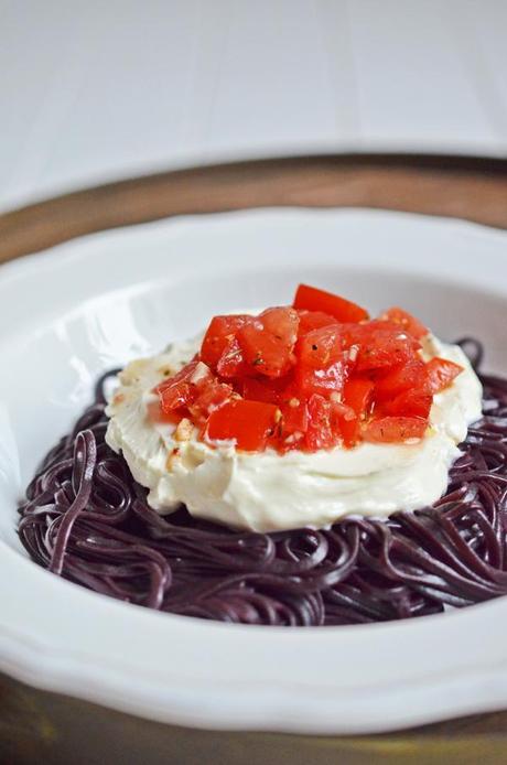 Abendtüte: schwarze Reisnudeln mit Tomaten und Ziegenfrischkäse