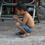 Kleiner Junge spielt auf der Straße