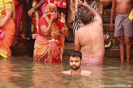 Gläubgiger Inder meditiert im heiligen Fluss Ganges