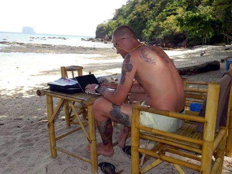 Bibo schreibt den Reisebericht am Strand von Koh Bulon
