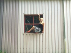 Gefährliche Pose in Fensterrahmen
