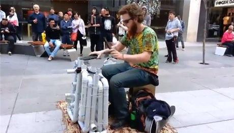 Straßenmusiker spielt elektronische Musik mit PVC Rohr und Flip Flops