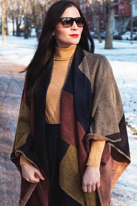 Kleidermädchen präsentiert ein winterliche Outfit-Kombination mit Cape und Faltenrock. Mit Rollkragenpullover von asos, Rock von Mango, Stiefeletten von Dressforless, Cape von Topshop und Sonnenbrille von Ralph Lauren.