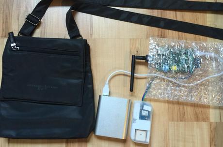 Wardrive (walk) Ausrüstung von links nach rechts: Tasche, Accu, GPS Empfänger mit Antenne im Gehäuse von einem alten USB-Stick, Raspberry Pi in Balsenfolie als Verpackung inkl. WLAN Antenne