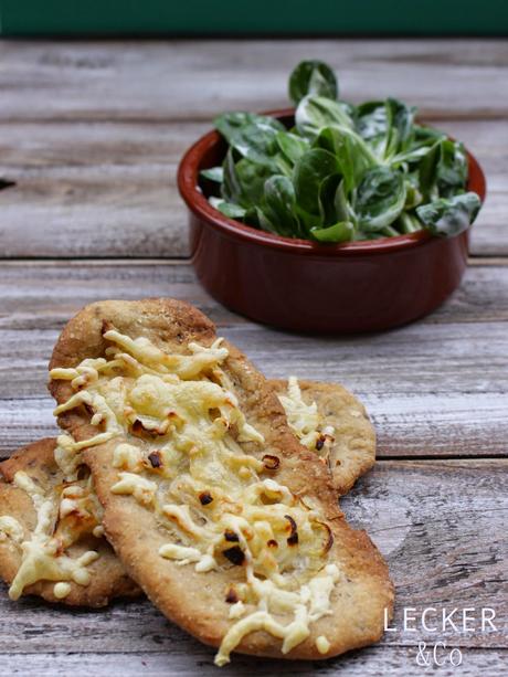 Gewürz-Brotfladen mit Zwiebeln, Speck und Käse und Feldsalat Gewürz-Brotfladen mit Zwiebeln, Speck und Käse und Feldsalat