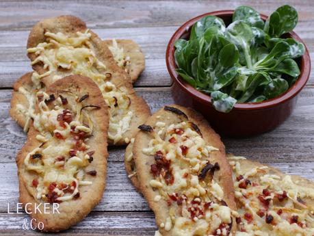 Gewürz-Brotfladen mit Zwiebeln, Speck und Käse und Feldsalat Gewürz-Brotfladen mit Zwiebeln, Speck und Käse und Feldsalat