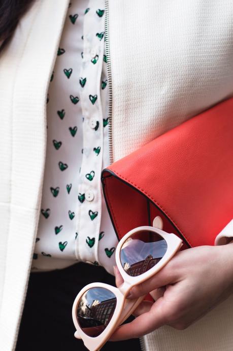Kleidermädchen präsentiert einen Frühlingslook mit Herzbluse von Mango und Adidas Sneakers in Weiß, Grün und Schwarz.