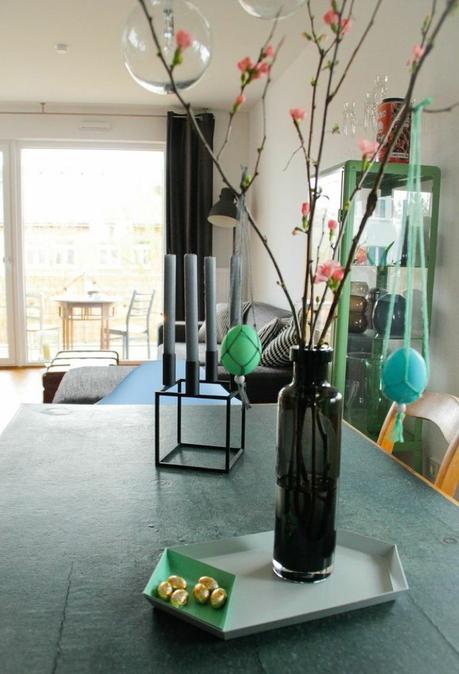 Esszimmerblick mit Ikea Vase und Quittenzweige, hängende Makramee Ostereier und by Lassen Kerzenständer mit grauen Kerzen