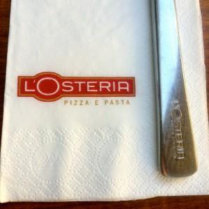 L'Osteria Branding auf einer Serviette und dem Besteckgriff