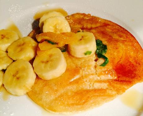 Pancake mit Bananenstücken, durchtränkt von Ahornsirup mit Minze