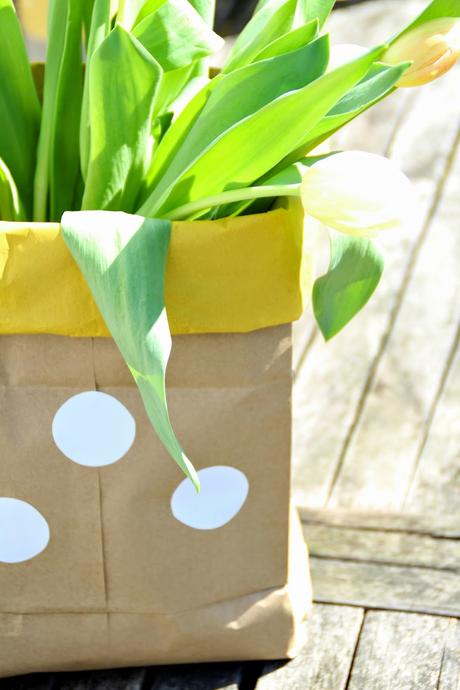 Braune Paperbag mit gelbem Rand und weißen Punkten als Vase für Tulpen