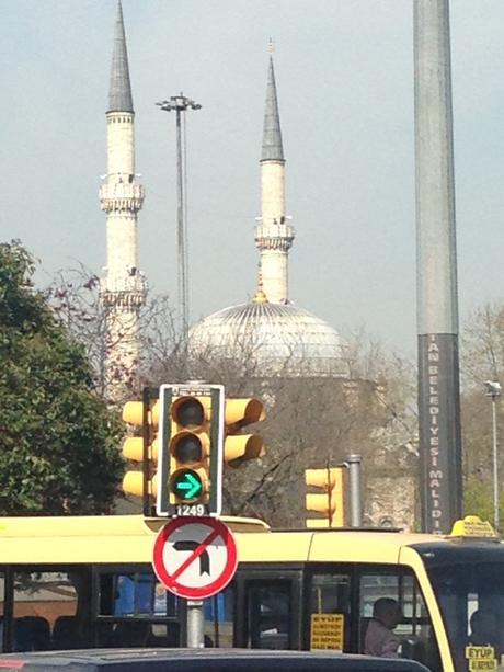 Die Minaretts der Sultan Moschee in Eyüp ragen in den Himmel. Die Ampel steht auf grün. Der Busfahrer fährt los.